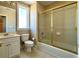 Bathroom with a large vanity, toilet, and tiled shower/tub with gold-framed sliding doors at 8008 Revere Dr, Mcdonough, GA 30252