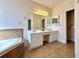 Bright bathroom with double vanity, soaking tub, and tile flooring at 8008 Revere Dr, Mcdonough, GA 30252