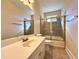 Bathroom with a large vanity, toilet, and tiled shower/tub with gold-framed sliding doors at 8008 Revere Dr, Mcdonough, GA 30252