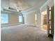 Expansive bedroom with tray ceiling, carpet flooring, and ensuite bathroom access at 8008 Revere Dr, Mcdonough, GA 30252