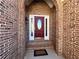 Elegant red front door framed by brick, with sidelights and a decorative oval glass insert at 8008 Revere Dr, Mcdonough, GA 30252