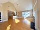 Open living room with fireplace, hardwood floors, vaulted ceiling, and view into the kitchen at 8008 Revere Dr, Mcdonough, GA 30252