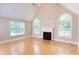Bright living room featuring high ceilings, a fireplace, hardwood floors, and arched windows at 8008 Revere Dr, Mcdonough, GA 30252