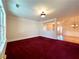 Spacious living room with red carpet, large window, and a partial view into the entry hall at 8008 Revere Dr, Mcdonough, GA 30252