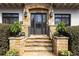 Inviting stone front entrance with black framed glass door, detailed stonework, and manicured landscaping at 1100 Virginia Ne Ave, Atlanta, GA 30306