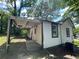 Quaint home featuring a covered porch, white siding, and dark trim, nestled among mature trees at 1199 Warfield Nw St, Atlanta, GA 30318