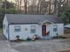 Charming single-story home with a red front door and a cozy front yard seating area at 2077 Brockett Rd, Tucker, GA 30084