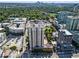 Aerial view of high-rise apartment building surrounded by lush trees and city buildings at 325 E Paces Ferry Ne Rd # 907, Atlanta, GA 30305