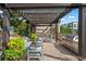 Outdoor kitchen with a stainless steel grill, seating area, and lush landscaping under a pergola with string lights at 325 E Paces Ferry Ne Rd # 907, Atlanta, GA 30305