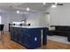 Open concept kitchen with navy blue island, gold hardware, quartz countertop, and seamless flow into living area at 1305 Country Acres Ln, Lawrenceville, GA 30045