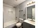 A modern bathroom featuring a shower-over-bath, gray vanity and black accessories at 1502 Huntingdon Chase, Atlanta, GA 30350