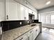 Kitchen featuring ample natural light, white cabinets, granite countertops, and stainless steel sink at 1502 Huntingdon Chase, Atlanta, GA 30350