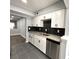 View of the kitchen showcases modern design with granite countertops, white cabinets, and tiled floor at 1502 Huntingdon Chase, Atlanta, GA 30350