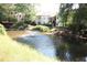 A pond with a water fountain in front of a multi-story condominium building at 1502 Huntingdon Chase, Atlanta, GA 30350