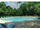 A large community pool with multiple lounge chairs and umbrellas at 1502 Huntingdon Chase, Atlanta, GA 30350