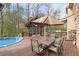 Backyard deck with table, seating, a screened-in structure, and above ground pool at 3175 Pond Ridge Trl, Snellville, GA 30078