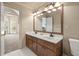Bright bathroom with a double sink vanity and a large mirror with decorative lighting at 3175 Pond Ridge Trl, Snellville, GA 30078