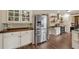 Well-lit kitchen with stainless steel refrigerator, white cabinetry, and hardwood flooring at 3175 Pond Ridge Trl, Snellville, GA 30078