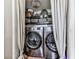 Modern laundry closet featuring front load washer and dryer, shelving and curtains in the laundry room at 4853 Chapelle Ct, Marietta, GA 30066