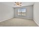 Bright bedroom with neutral carpet, ceiling fan, and a large window at 7316 Wagon Wheel Ct, Jonesboro, GA 30236
