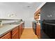 Well-lit kitchen featuring wooden cabinets, black appliances, and a double sink at 7316 Wagon Wheel Ct, Jonesboro, GA 30236