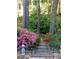 Landscaped path winds through a lush garden with vibrant flowering bushes and mature trees at 994 Fairview Club Cir, Dacula, GA 30019