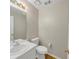 A well-lit half bathroom featuring a white vanity, commode, and a decorative light fixture at 742 Wilkes Dr, Loganville, GA 30052