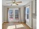 Bright dining area features wood floors, ceiling fan, and double doors to outdoor deck at 742 Wilkes Dr, Loganville, GA 30052
