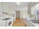 A bright kitchen featuring white cabinets, countertops, and stainless steel appliances at 742 Wilkes Dr, Loganville, GA 30052