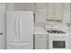 A kitchen featuring white cabinets, appliances, and countertops providing a bright, clean aesthetic at 742 Wilkes Dr, Loganville, GA 30052