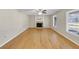 Open-concept living room with hardwood floors, a fireplace, and natural light from large windows at 742 Wilkes Dr, Loganville, GA 30052