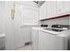 Clean laundry room with white appliances and matching white walls and cabinets at 1672 Zemory Dr, Tucker, GA 30084
