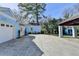 Backyard featuring a light blue home, a large concrete patio, and a detached carport at 1926 N Decatur Ne Rd, Atlanta, GA 30307