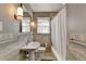 Elegant bathroom with neutral tile, a framed mirror, a window with curtains, and a combined tub and shower at 1926 N Decatur Ne Rd, Atlanta, GA 30307
