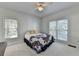 Cozy bedroom with a ceiling fan, two bright windows, and a comfortable bed with a patterned quilt at 1926 N Decatur Ne Rd, Atlanta, GA 30307
