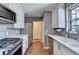 Galley kitchen featuring stainless steel appliances, white cabinets, and brick flooring at 1926 N Decatur Ne Rd, Atlanta, GA 30307