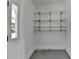 White storage area with shelving, a window, access to the exterior, and gray floor at 1926 N Decatur Ne Rd, Atlanta, GA 30307