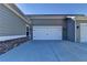 View of the exterior of the garage with a white door, black hardware, and gray siding at 2908 Rambler Dr, Loganville, GA 30052