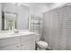 Modern bathroom features sleek white vanity, chrome shelving, and a stylish striped shower curtain at 3651 Princeton Ave, Atlanta, GA 30337