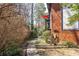 Walkway to an apartment building featuring a red umbrella on a balcony, with mature trees in the background at 6851 Roswell Rd # L1, Atlanta, GA 30328