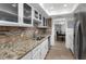 Well-lit kitchen with stainless steel appliances, granite countertops and updated white cabinets at 6851 Roswell Rd # L1, Atlanta, GA 30328