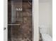 The shower is lined with stone-look tiles and equipped with a glass door and rainfall shower head at 6851 Roswell Rd # L1, Atlanta, GA 30328