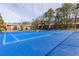 Bright blue tennis court surrounded by trees and apartment buildings under a partly cloudy sky at 6851 Roswell Rd # L1, Atlanta, GA 30328