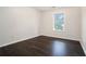 A simple bedroom has dark hardwood floors and one window at 725 Victoria Station Blvd, Lawrenceville, GA 30043