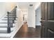 Bright foyer with hardwood floors, elegant staircase, and white wainscoting, leading to the kitchen area at 725 Victoria Station Blvd, Lawrenceville, GA 30043