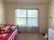 A cozy bedroom features neutral walls decorated with polka dots and a large window at 15 Blanket Pass, Covington, GA 30016