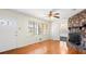 Inviting living room with a stone fireplace, large windows, and warm hardwood flooring at 1729 Norden Rd, Riverdale, GA 30296