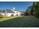 Wide shot of a large backyard with a green lawn and view of the white house with a dark roof at 3125 Crooked Stick Dr, Cumming, GA 30041