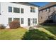 An expansive backyard with a patio and outdoor furniture set against a house with many windows at 3125 Crooked Stick Dr, Cumming, GA 30041