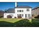 Spacious backyard featuring a well-maintained lawn, a patio set, and a house with a dark roof at 3125 Crooked Stick Dr, Cumming, GA 30041